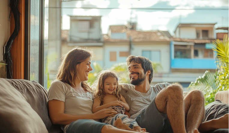 Família brasileira reunida em uma sala de estar aconchegante, destacando um ambiente bem decorado e acolhedor.